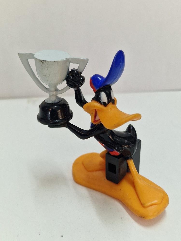 Figura Pvc: Pato Lucas (Daffy Duck) sujetando un trofeo