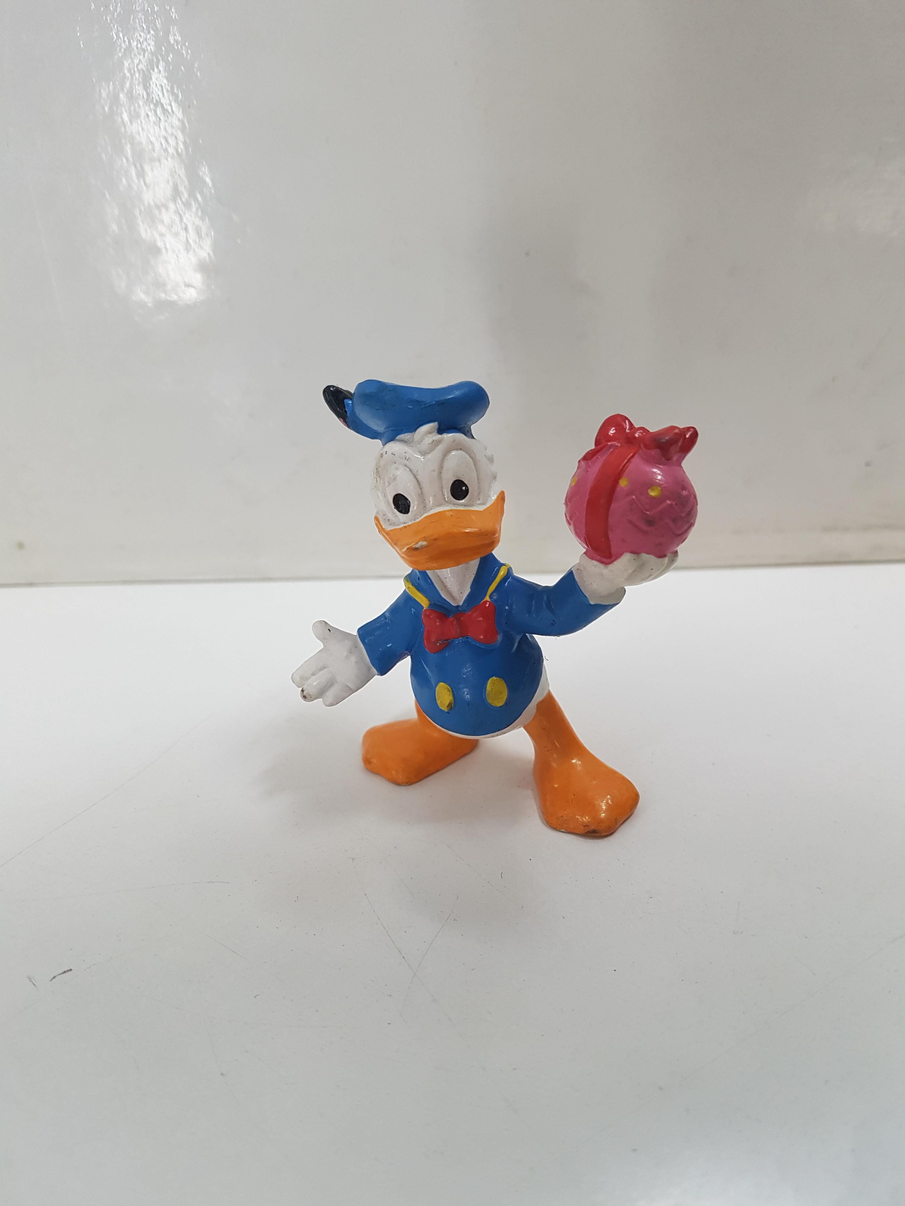 Figura del pato Donald, regalo en la mano. Disney