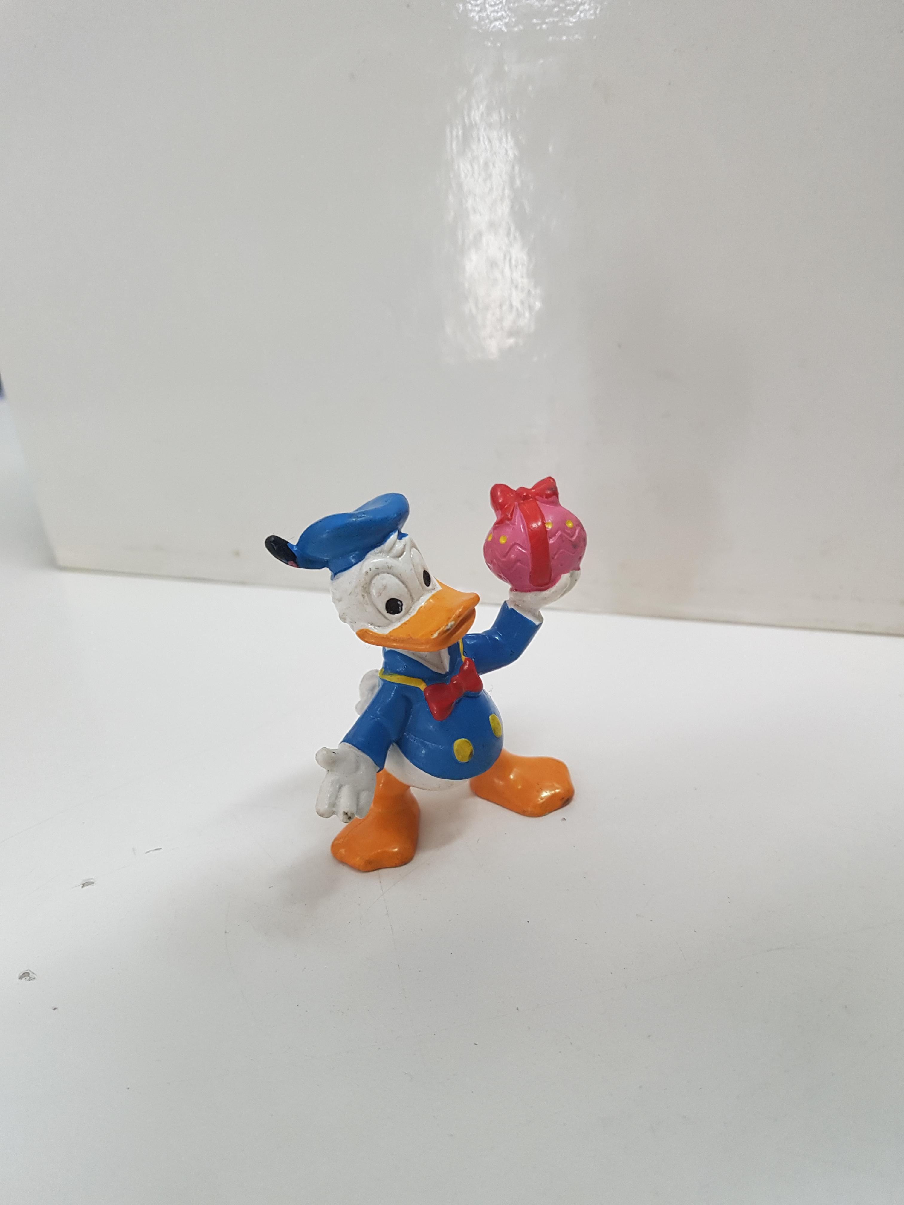 Figura del pato Donald, regalo en la mano. Disney