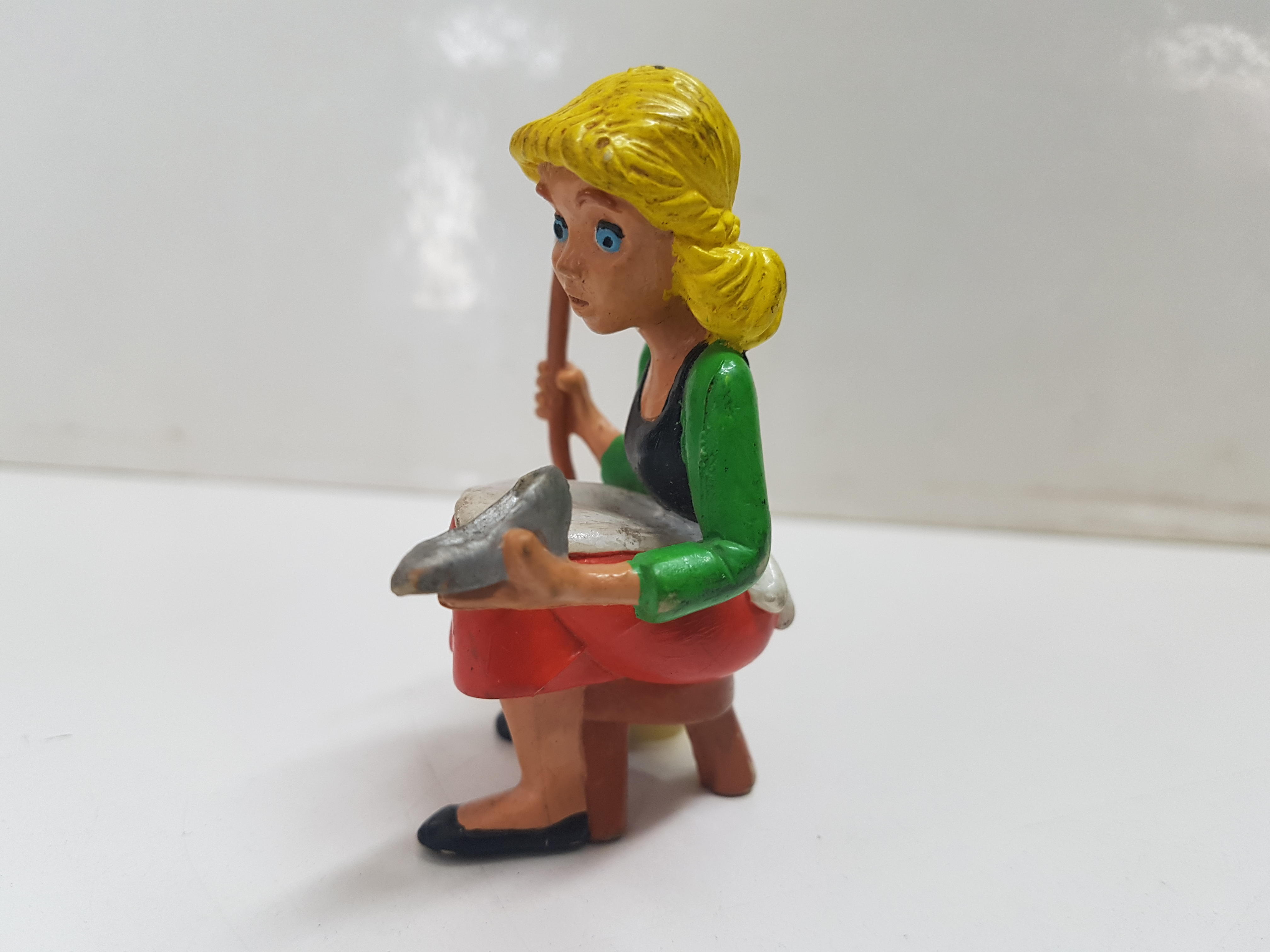 Figura de Cenicienta sentada en taburete, sujetando zapato y escoba 