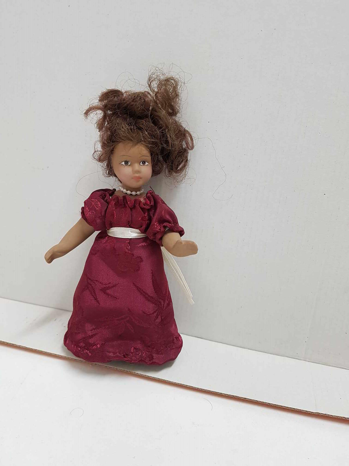 Muñeca de porcelana de los años 80: con vestido granate y collar de perlas