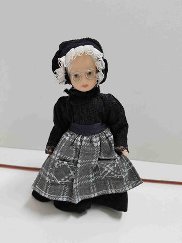 Muñeca de porcelana de los años 80: anciana con gafas y vestifo negro