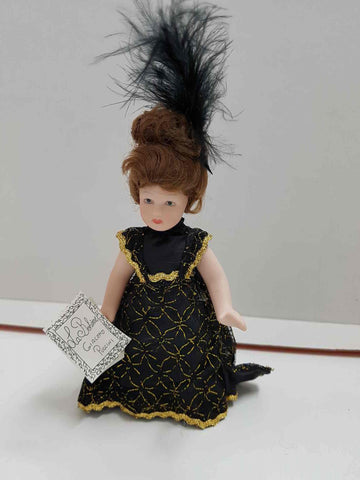 Muñeca de porcelana de los años 80: vestido negro-dorado y plumas negras en el cabello