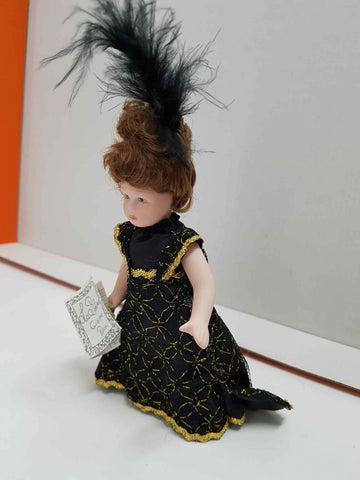 Muñeca de porcelana de los años 80: vestido negro-dorado y plumas negras en el cabello