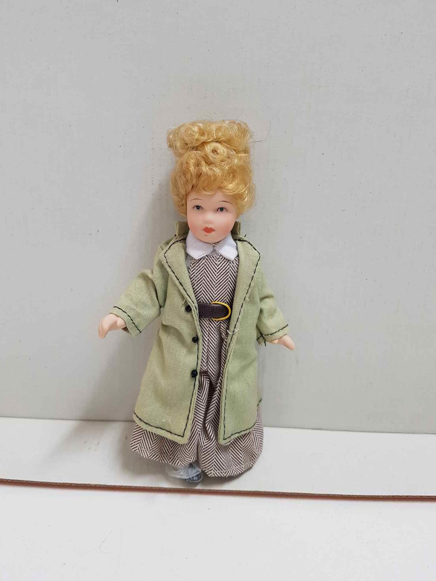 Muñeca de porcelana de los años 80: rubia con gabardina verde