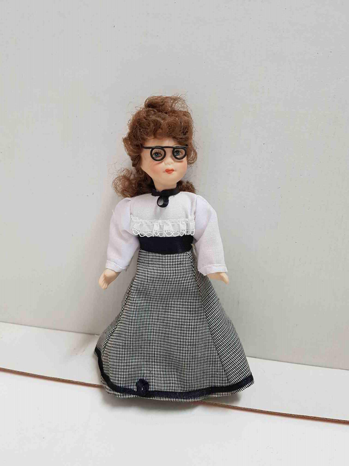 Figura de muñeca de porcelana años 80: lleva gafas y vestido negro y blanco