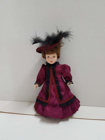 Figura de muñeca de porcelana años 80: vestido purpura y negro, sombrero con plumas del mismo color