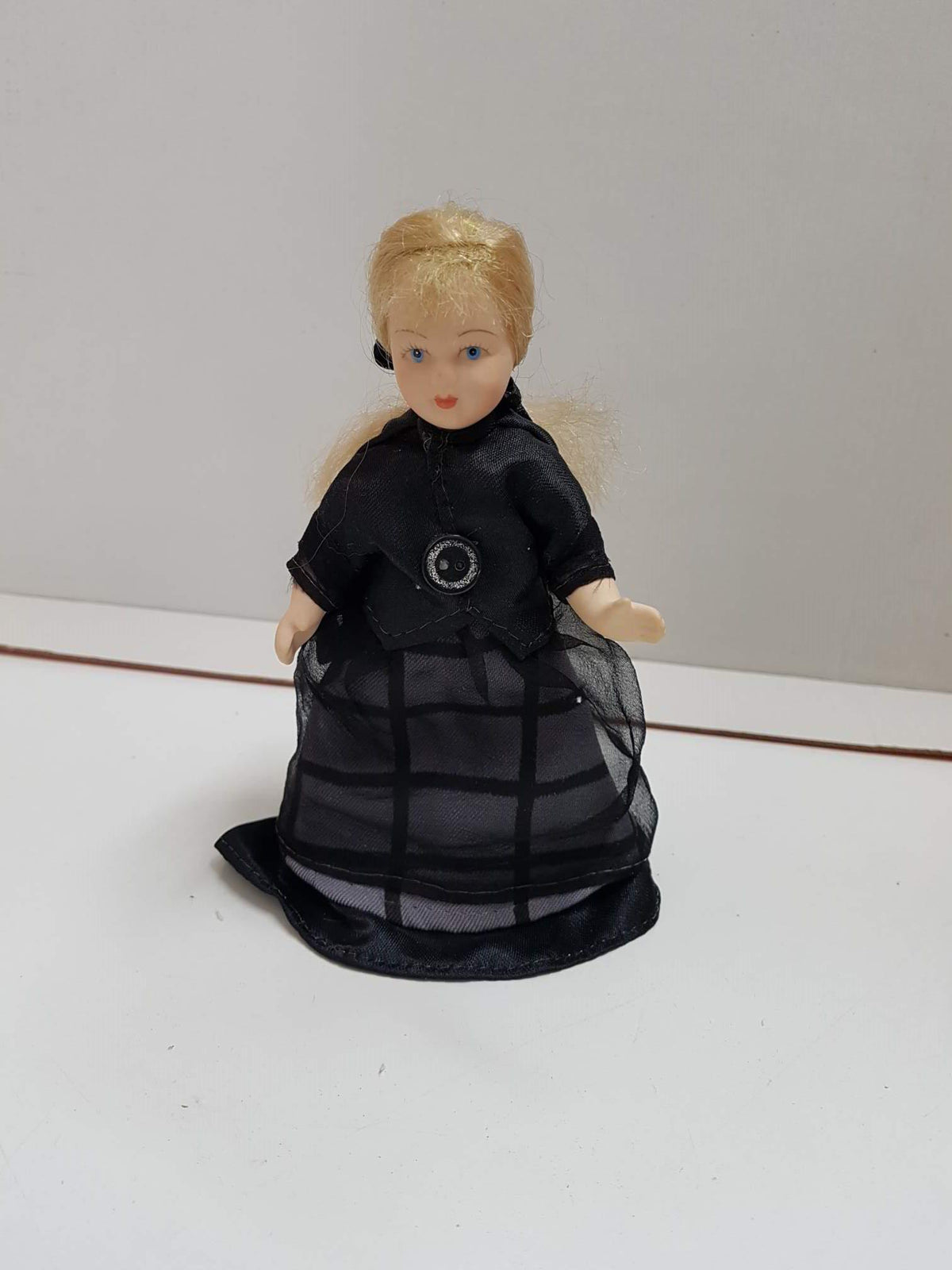 Figura de muñeca de porcelana años 80: Rubia con una cinta de pelo y vestida toda de negro