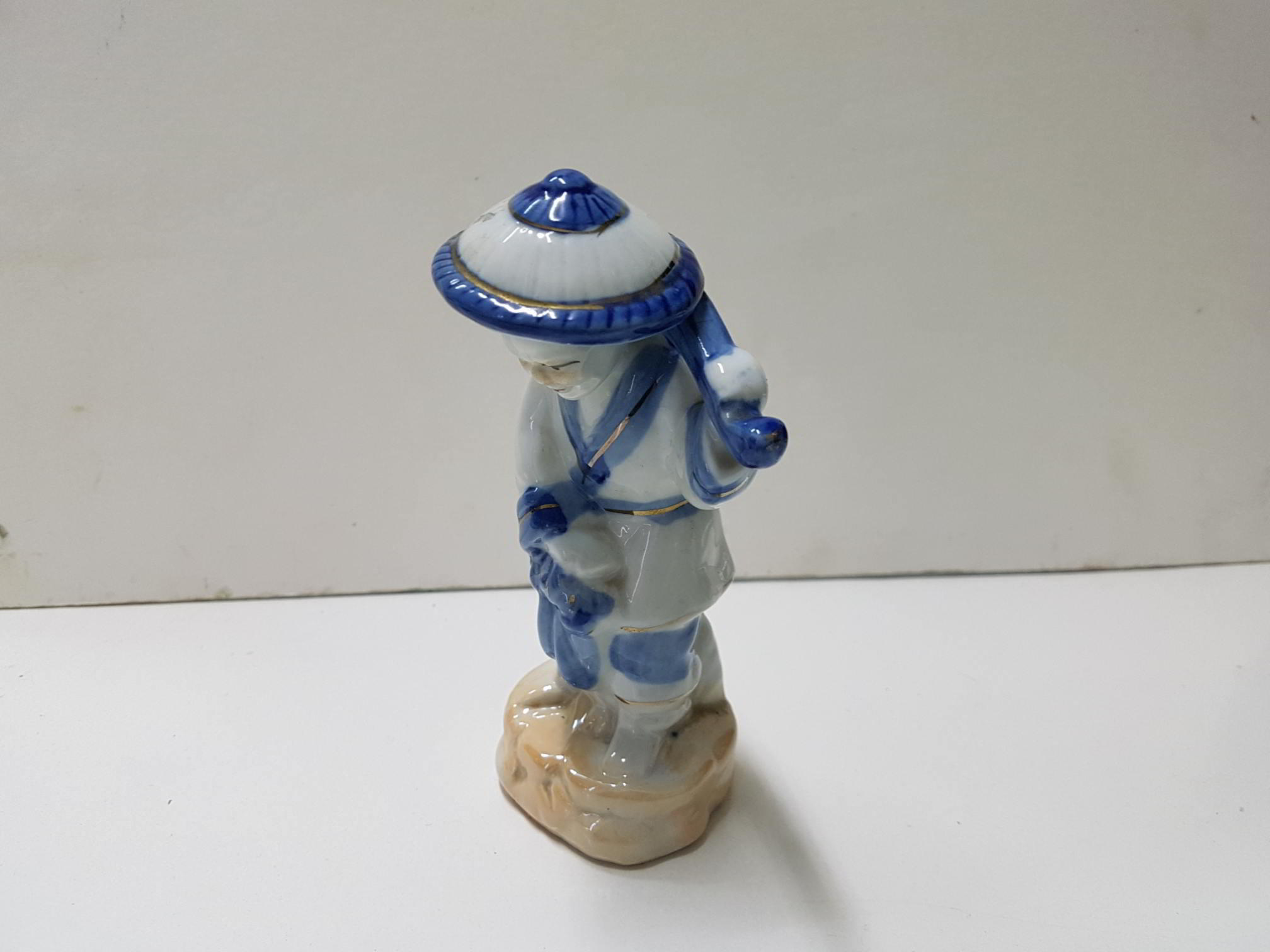 Figura anciana china, con sombrero y palo sobre el hombro. Imperfeccion en el sombrero