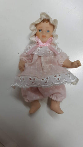 Figura porcelana: Muñeca niña pequeña con articulaciones moviles. Vestido rosa y blanco