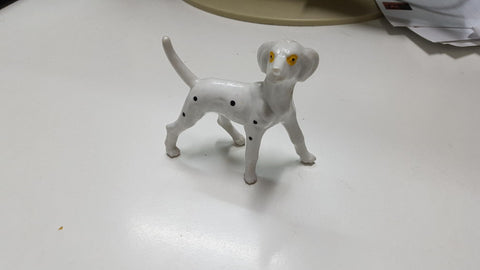 Figura: Perro con manchas negra y ojos amarillos. De material tipo ceramica o similar