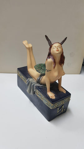 Figura de fantasia: Hada con cuernos tumbada sobre un pedestal