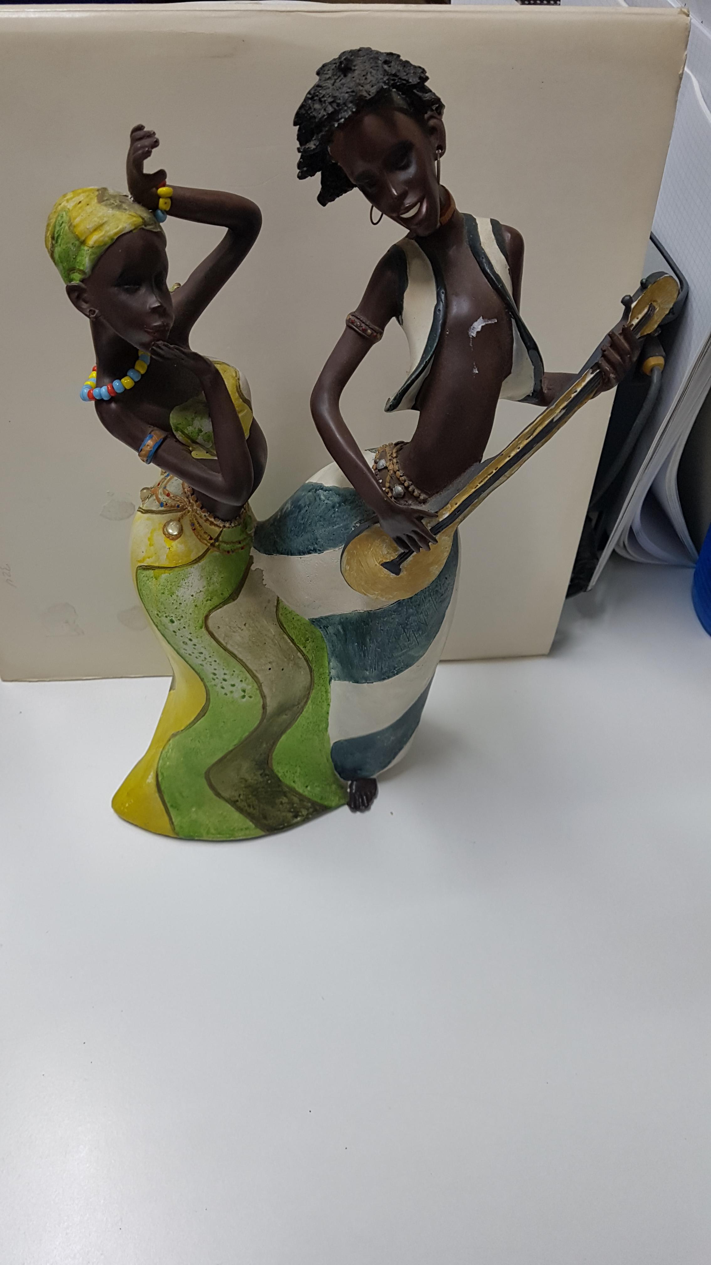 Figura: Dos africanas bailando y tocando musica con instrumento de cuerda