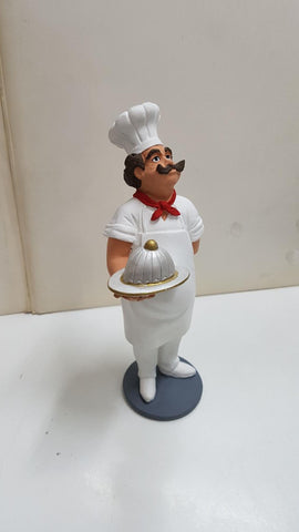 Figura de resina artesanal: Cocinero con delantal y gorro llevando bandeja tapada