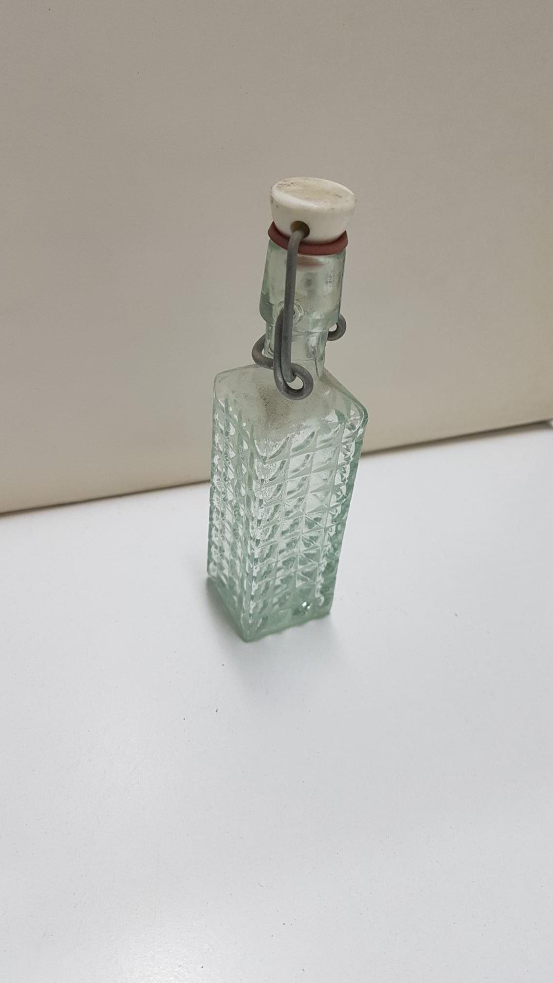 Botella  de cristal de tamaño mini con forma cuadrada y tapon mecanico. 13 cm de alto